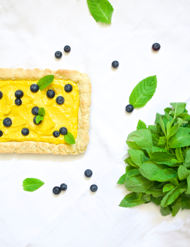 white chocolate mango curd tart with mint and blueberries