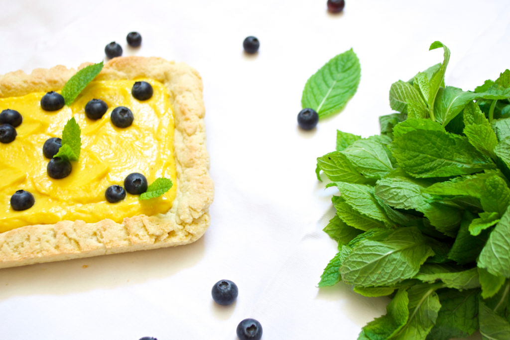 white chocolate mango curd tart with mint and blueberries