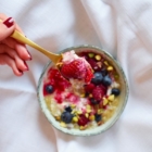 quinoa porridge with coconut milk berries and shredded pistachios spoon